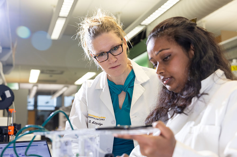 Iowa researcher Georgina Aldridge works with a fellow colleague in a laboratory.